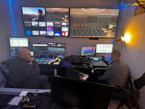 Two AV specialists sitting in a control room at Cure, monitoring video. 