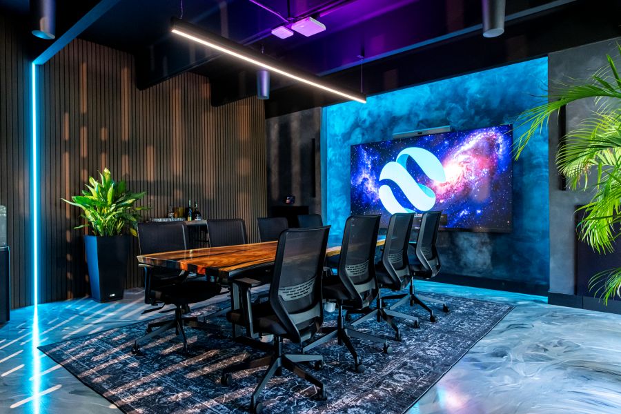 The Conference Room of the Universe with an LED video wall, LED lighting, pendant speakers, and a beautiful table.